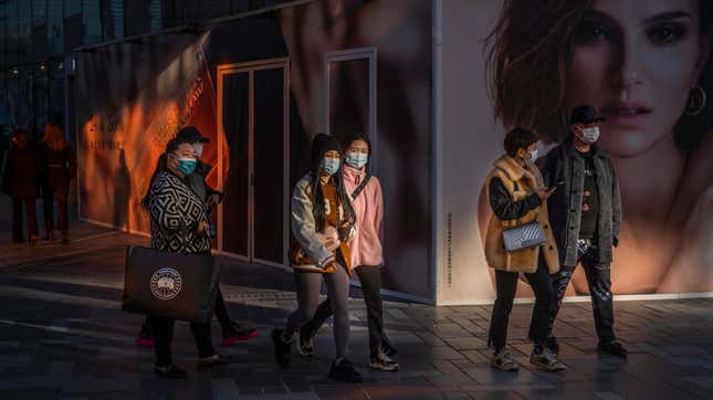 People walk by an ad for DIOR outside a new location set to open at a shopping area on November 24, 2021 in Beijing, China. 