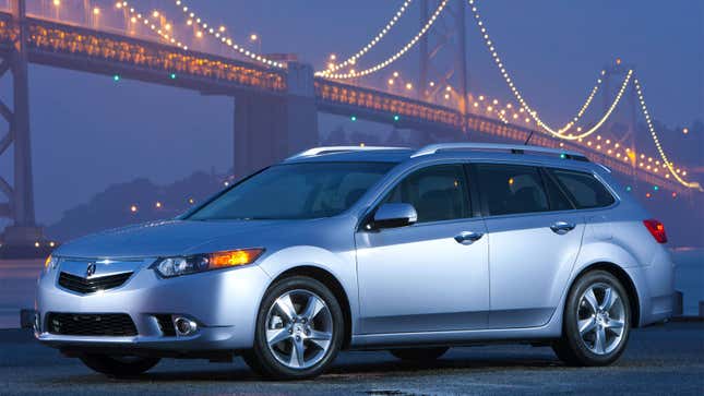 A photo of a silver Acura TSX wagon in front of a bridge. 