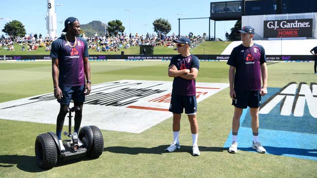 A photo of a cricket player standing on a Segway. 