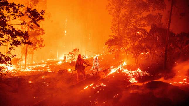 A firefighter works the scene as flames push towards homes during the Creek Fire in 2020.