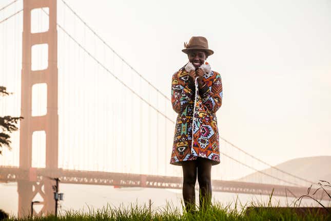 Black woman wearing colorful coat by Golden Gate Bridge, San Francisco, California, United States