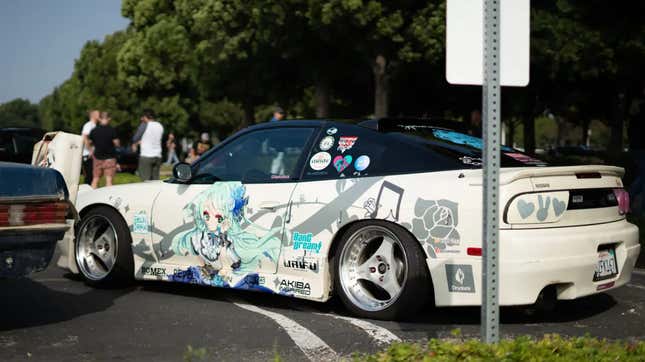 A white Nissan NSX covered in anime decals. 