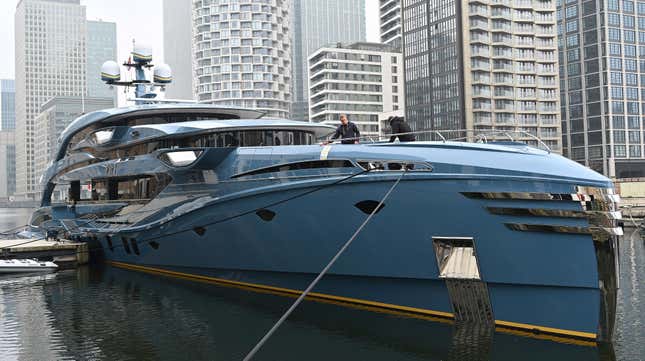 A member of the crew cleans the bow of the PHI superyacht, impounded by a unit of Britain’s National Crime Agency 