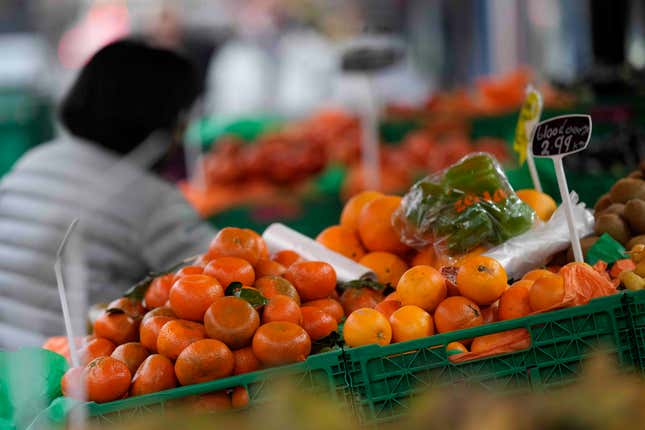 FILE - A woman looks at fruit and vegetables on sale at a stall in London, Tuesday, Feb. 28, 2023. Inflation across the U.K. fell unexpectedly in August to its lowest level since Russia launched its invasion of Ukraine, raising hopes that the Bank of England may pause interest rate hikes after another one on Thursday. It said that lower hotel and air fare costs and a moderation in food price rises. (AP Photo/Alastair Grant, File)