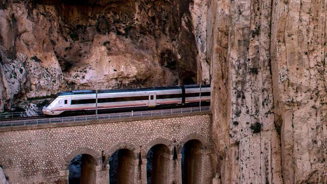 A photo of a train coming out a tunnel in Spain. 