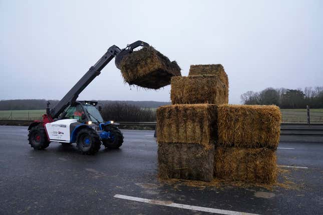 A highway service car removes hay bales let by famers after they lift a blockade, Friday, Feb. 2, 2024 in Les Ulis, south of Paris. France&#39;s two major farmers unions announced they would lift country-wide blockades Thursday, shortly after the prime minister introduced new measures aimed at protecting their livelihoods that they described as &quot;tangible progress.&quot; (AP Photo/Michel Euler)