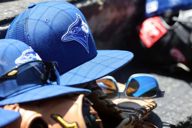 Mar 18, 2022; Sarasota, Florida, USA; A detail view of a Toronto Blue Jays hat and glove in the dugout during spring training against the Baltimore Orioles at Ed Smith Stadium.