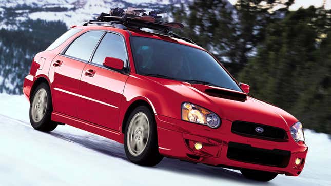 A photo of a red Subaru WRX wagon driving on snow. 