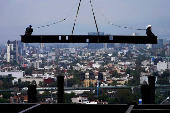 FILE - Construction workers sit on a beam hanging from a crane at a construction site of a residential high rise building, in Mexico City, June 17, 2022. Mexico’s president said Friday, Dec. 1, 2023, the country’s minimum wage will rise by 20% in 2024, to the equivalent of about $14.25 per day. (AP Photo/Marco Ugarte, File)