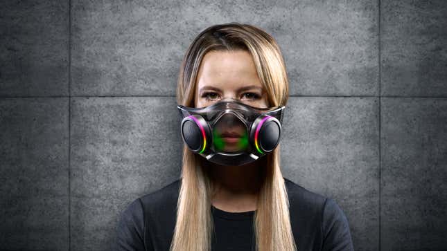 A photo of a woman wearing Razer's new Zephyr air filtration mask, which looks like an RGB cybergoth accessory. 