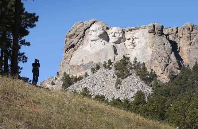 KEYSTONE, SD - OCTOBER 01: A tourist takes a picture of Mount Rushmore National Memorial from outside the park on October 1, 2013 in Keystone, South Dakota.