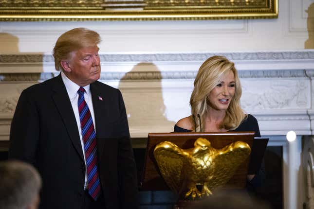 Pastor Paula White leads a prayer beside U.S. President Donald Trump during a dinner celebrating Evangelical leadership in the State Dining Room of the White House in Washington, D.C., U.S.,on Monday, Aug. 27, 2018. After the American Legion wrote a letter imploring recognition of late Senator John McCain, Trump relented during his dinner speech stating “We very much appreciate everything that Senator McCain has done for our country.”