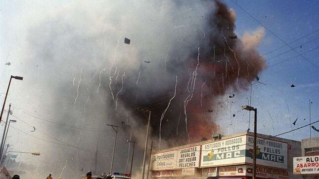Rescue workers and residents flee as a fourth explosion sounds at a market area in downtown Celaya, Mexico, Sunday, Sept. 26, 1999. At least 56 people were killed when a series of explosions erupted, sparked by a supply of gunpowder used for making fireworks.