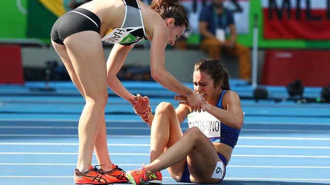 Abbey D'Agostino of the United States (R) is assisted by Nikki Hamblin of New Zealand after a collision during the a heat in the Women's 5000m at the Rio 2016 Olympics.