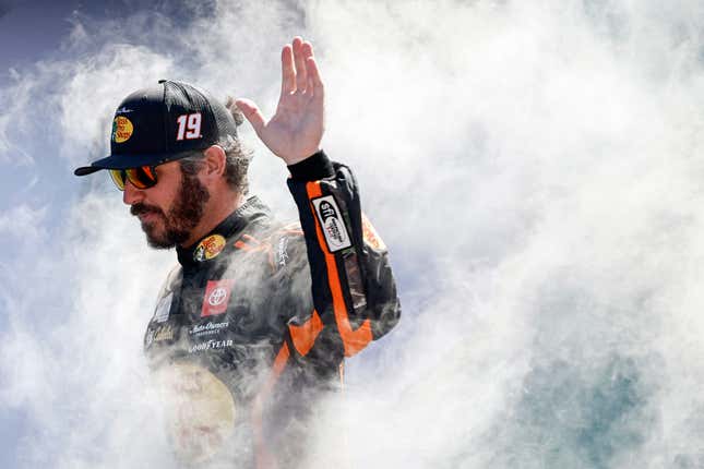 Martin Truex Jr., driver of the No. 19 Bass Pro Shops Toyota, waves to fans as he walks onstage during driver intros prior to the NASCAR Cup Series Dixie Vodka 400 at Homestead-Miami Speedway on October 23, 2022 in Homestead, Florida.