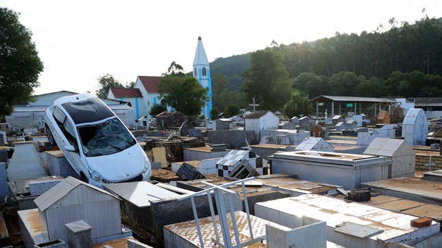 A destroyed car is seen on top of tombstones at the cemetery after a cyclone in Caraa, Brazil on June 19, 2023