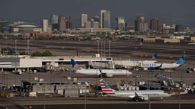 12 Temmuz 2023'te Phoenix, Arizona'daki Sky Harbor Uluslararası Havaalanı'nda şehir silüetine karşı kapılarında duran uçaklar.
