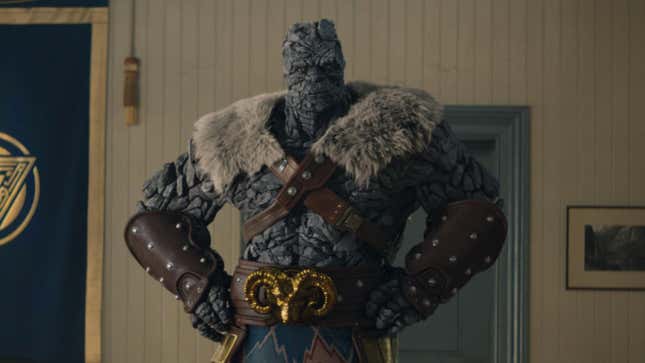 Korg standing with his hands on hips.