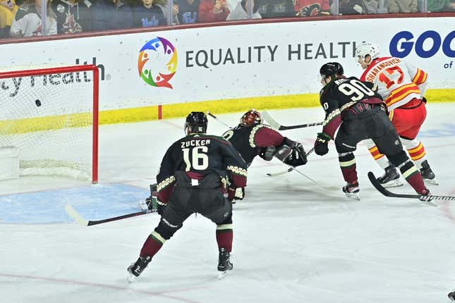 Jan 11, 2024; Tempe, Arizona, USA; Calgary Flames center Yegor Sharangovich (17) scores a short handed goal on Arizona Coyotes goaltender Karel Vejmelka (70) as left wing Jason Zucker (16) and defenseman J.J. Moser (90) defend in the first period at Mullett Arena.