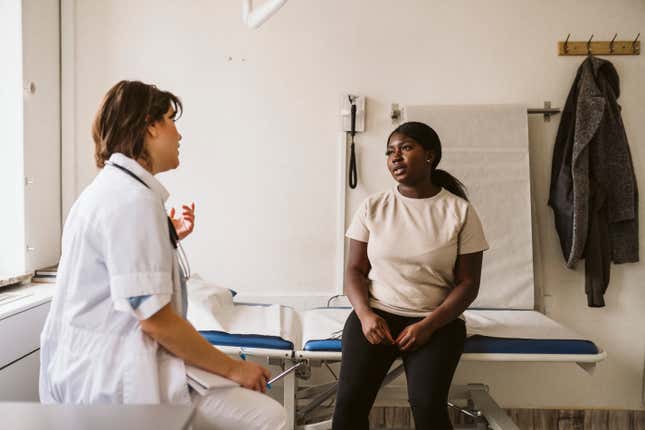 Black woman speaking with her doctor. 