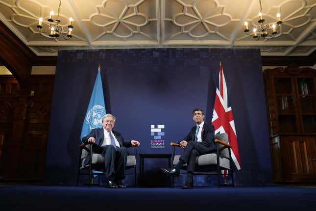 Antonio Guterres and Rishi Sunak sitting in chairs in front of the UN and union Jack flags in front of a backdrop for the AI safety summit