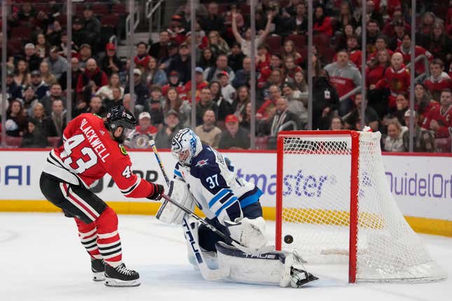 CHICAGO, ILLINOIS - FEBRUARY 23: Colin Blackwell #43 of the Chicago Blackhawks scores a goal against Connor Hellebuyck #37 of the Winnipeg Jets during the second period at the United Center on February 23, 2024 in Chicago, Illinois. (Photo by Patrick McDermott/Getty Images)