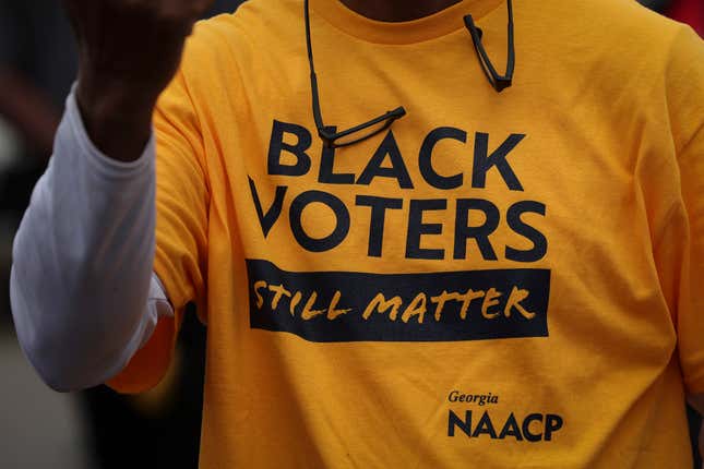 HEPHZIBAH, GEORGIA - DECEMBER 03: A member of the audience wearing a ‘Black Voters Still Matter’ t-shirt from Georgia NAACP as Georgia Democratic Senate candidate U.S. Sen. Raphael Warnock (D-GA) speaks during a Get Out the Vote rally December 3, 2022 in Hephzibah, Georgia. Sen. Warnock continues to campaign throughout Georgia for the runoff election on December 6 against his Republican challenger Herschel Walker.