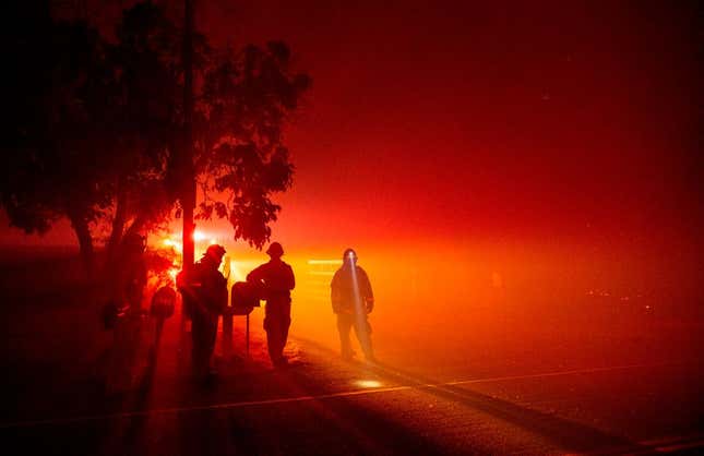 Firefighters monitor flames as they approach a residence in the valley area of Vacaville, northern California during the LNU Lightning Complex fire on August 19, 2020.