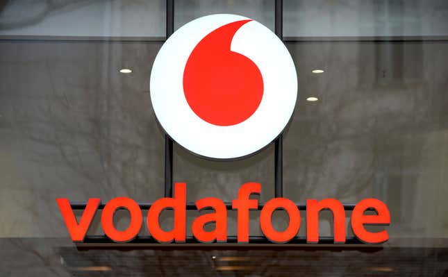 FILE - The logo of the mobile service provider &#39;vodafone&#39; is pictured on the entrance of a company&#39;s store at the Kurfuerstendamm shopping boulevard in Berlin, Germany, Tuesday, Feb. 1, 2022. British cellphone company Vodafone confirmed Friday, March 15, 2024, that it is selling its Italian business to Switzerland’s Swisscom for 8 billion euros ($8.7 billion) and will hand back half of the proceeds to its shareholders through the buyback of company shares. (AP Photo/Michael Sohn, File)