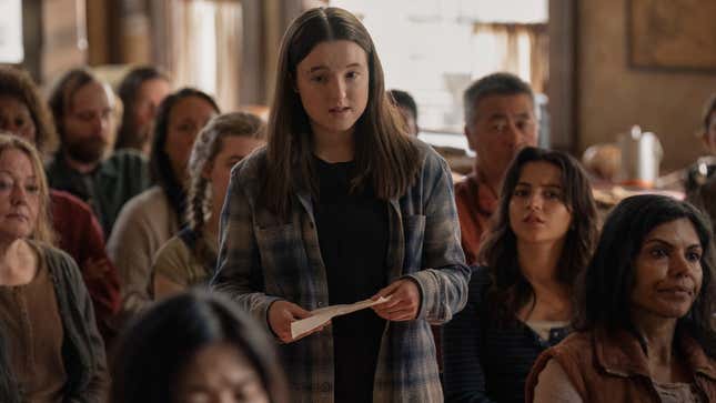 Ellie reads something off a sheet of paper to a crowd.