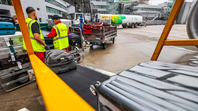 Suitcases are loaded onto a Eurowings plane to Mallorca by staff at Düsseldorf Airport.