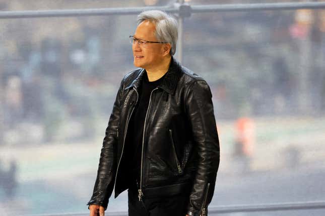 Jensen Huang wearing all black walking in front of a window with blurred people outside