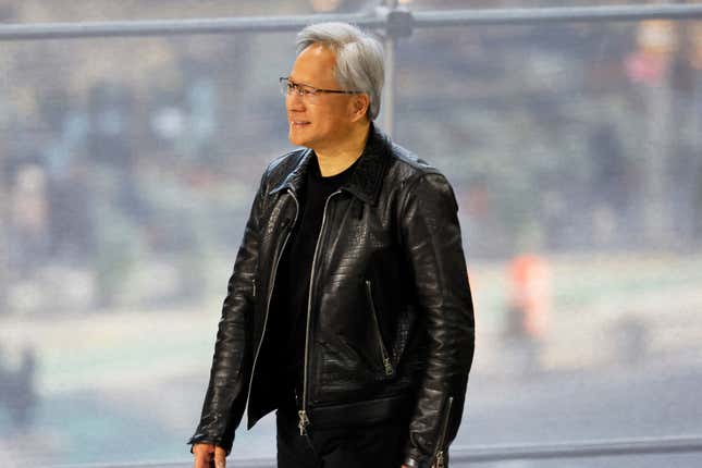 JensenHuang vêtu de noir marchant devant une fenêtre avec des gens flous à l’extérieur