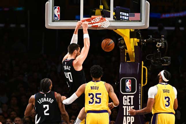 Nov 1, 2023; Los Angeles, California, USA;  LA Clippers center Ivica Zubac (40) dunks the ball against Los Angeles Lakers forward Christian Wood (35) and guard D&#39;Angelo Russell (1) during the first quarter at Crypto.com Arena.