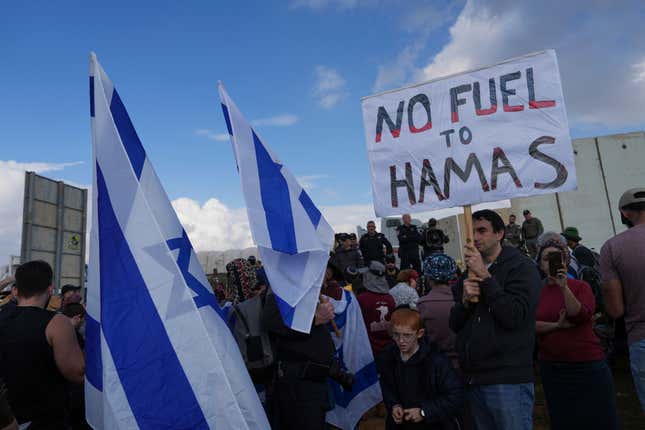 Israeli police prevent activists from blocking trucks carrying humanitarian aid into the Gaza Strip at the Kerem Shalom border crossing between Israel and Gaza, in southern Israel, Monday, Jan. 29, 2024. The activists say no aid should enter the territory until Israeli hostages held captive by the Hamas militant group are released. (AP Photo/Tsafrir Abayov)