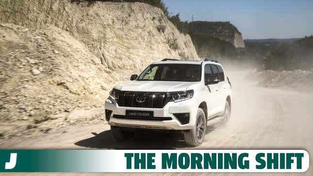 A photo of a Toyota Land Cruiser SUV driving on dirt. 