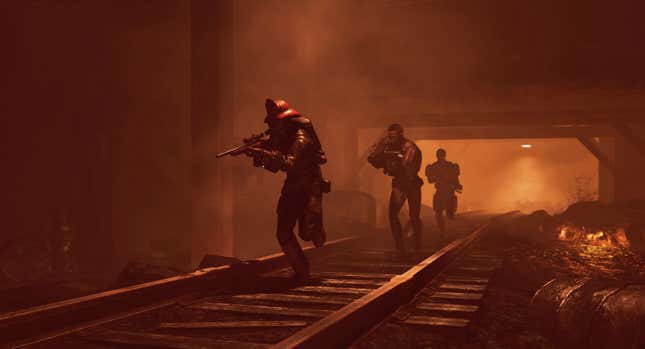 A squad of Fallout 76 players cooperating in what appears to be a dungeon in an udnerground mine. The player leading the charge is wearing a Firebreathers' helmet.