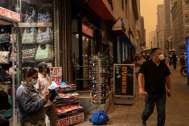 Una persona vende mascarillas afuera de una tienda de souvenirs en Nueva York el miércoles 7 de junio de 2023 mientras el humo de los incendios forestales envuelve la ciudad.
