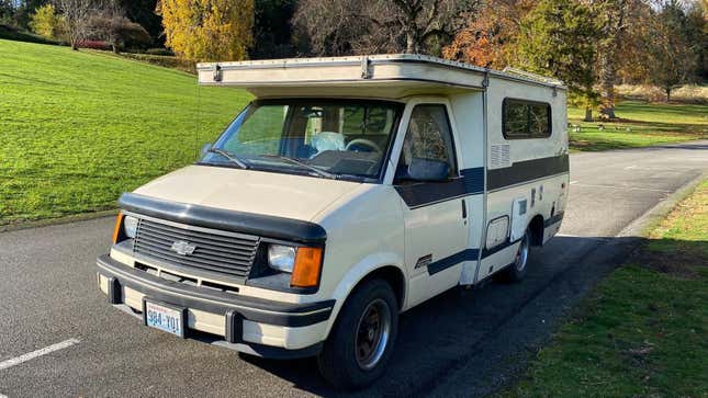 A front three quarters shot of the tan Astro camper with the pop top folded up