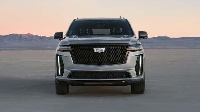 A silver Escalade V parked in a desert