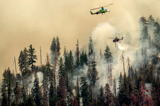 A helicopter drops water on the Washburn Fire burning through Yosemite National Park on Saturday, July 9.