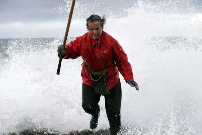 Elvira, a barnacles collector or a “percebeira’, escapes from a wave as she hunts for Gooseneck barnacles ahead of Christmas celebrations in the rough waters of Cape Roncudo, A Coruna, in the northwestern Spanish province of Galicia on Dec. 22.