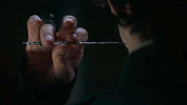 Reverend Mother Gaius Helen Mohiam's right hand holding up a poisoned needle to Paul Atreides' neck.