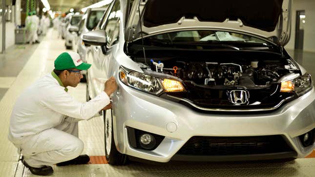 A photo of a mechanic building a Honda car. 