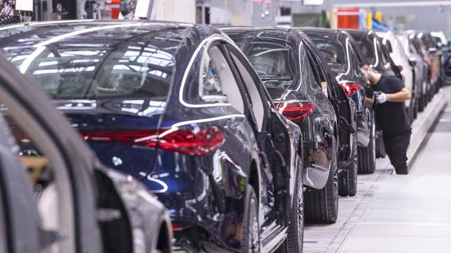 An employee is working on Mercedes-Benz EQS and S-Class passenger cars that are lined up at the "Factory 56", a completely digitalized assembly line, at the Mercedes-Benz manufacturing plant in Sindelfingen, southern Germany, on February 13, 2023. 