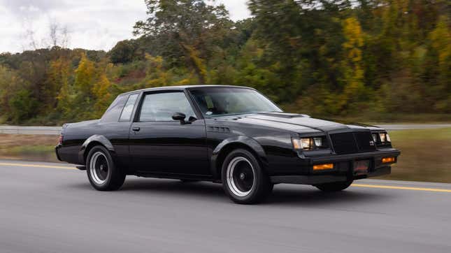 Une Buick GNX circulant sur une route devant des arbres