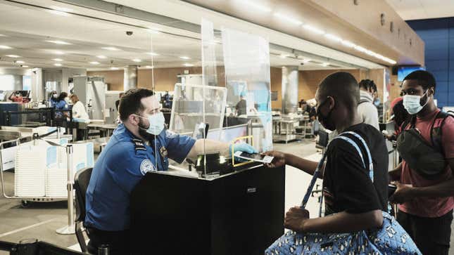 An agent handing back a passport at a TSA checkpoint