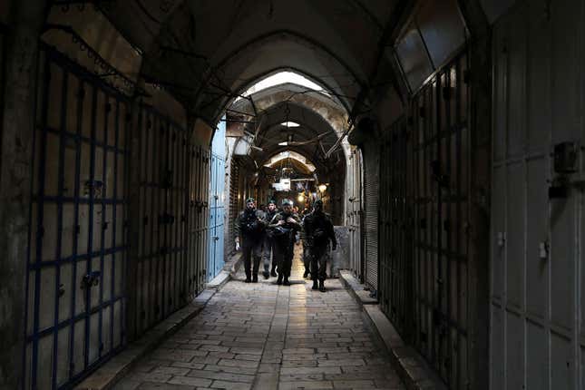 Israeli border police officers walk past closed shops as Palestinian political parties call for a general strike, in Jerusalem’s Old City