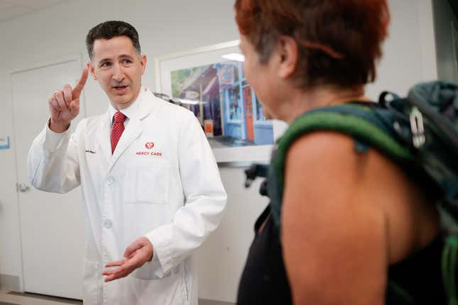 FILE - Dr. Reed Pitre, director of psychiatry and interim chief medical officer at Mercy Care clinic, left, speaks with a patient after her appointment, June 27, 2023, in Atlanta. Some Republican legislative leaders say they want to examine broader health care coverage through Georgia&#39;s Medicaid program in 2024. (AP Photo/Alex Slitz, File)