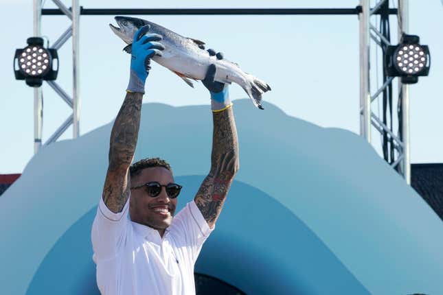 Seattle Kraken NHL hockey broadcaster JT Brown holds up a fish after he caught it Wednesday, July 21, 2021, during the Seattle Kraken’s NHL hockey expansion draft event in Seattle. The Seattle Kraken say they will make NHL history during Thursday night’s game against Winnipeg when play-by-play announcer Everett Fitzhugh and analyst JT Brown team up to form the first all-Black television broadcast crew to call an NHL game.